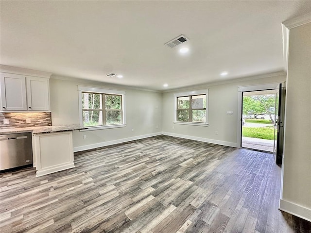 unfurnished living room with light hardwood / wood-style flooring, plenty of natural light, and crown molding