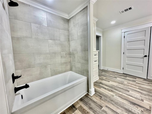 bathroom featuring tiled shower / bath combo, wood-type flooring, and crown molding