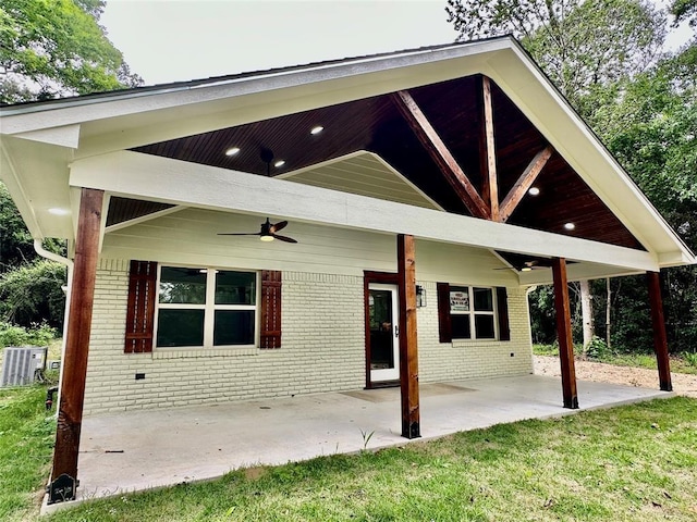 rear view of property with ceiling fan, a yard, and a patio