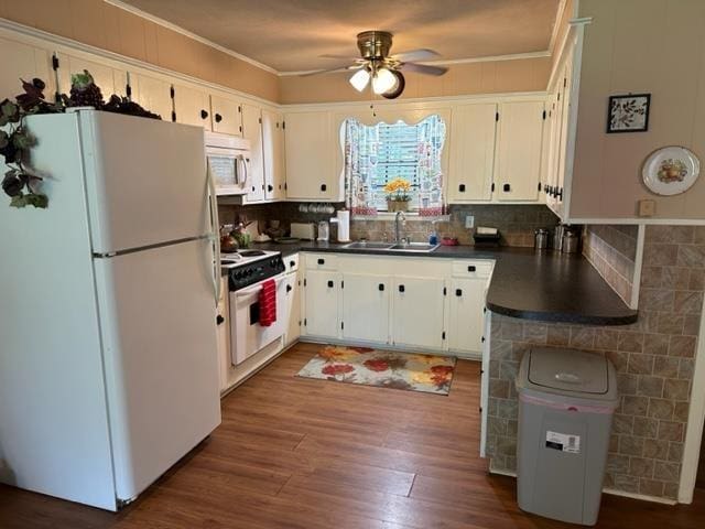 kitchen with white cabinets, decorative backsplash, white appliances, and sink