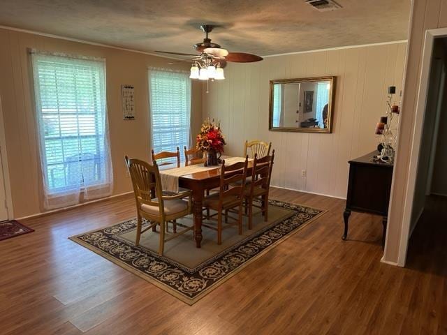 dining space featuring ceiling fan, dark hardwood / wood-style flooring, a textured ceiling, and ornamental molding