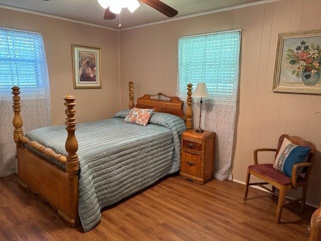 bedroom with ceiling fan, hardwood / wood-style floors, and ornamental molding