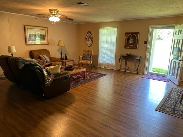 living room with wood-type flooring, a textured ceiling, and ceiling fan