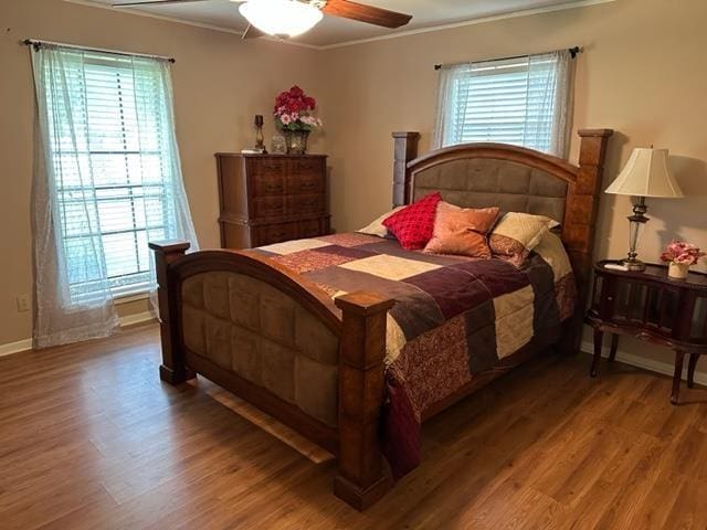 bedroom featuring ceiling fan, wood-type flooring, and ornamental molding