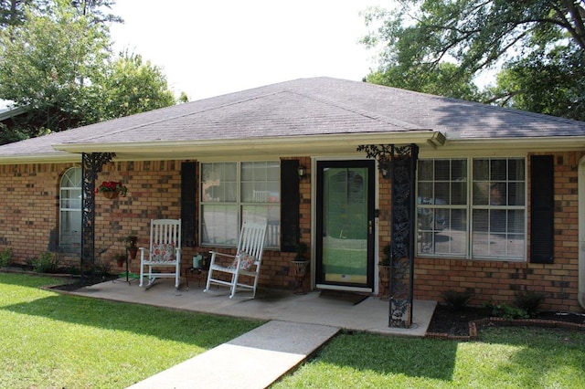 1003 Linton Lanier Ln, Jasper, TX 75951 - ranch-style home with brick siding, a front lawn, roof with shingles, and a porch