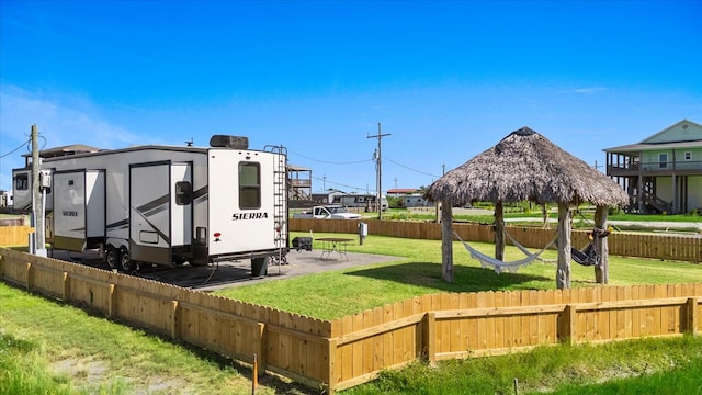 view of community featuring a lawn, a shed, and a patio