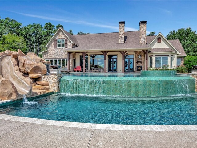 exterior space with an in ground hot tub, a patio, and a lawn