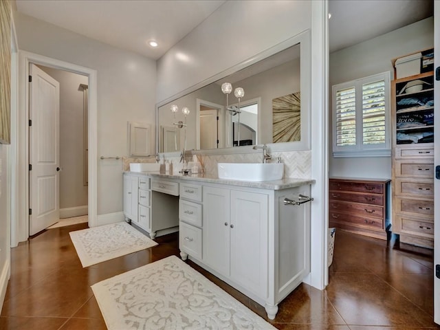 bathroom with backsplash, tile patterned flooring, and vanity