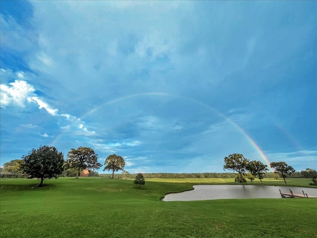 surrounding community with a lawn and a water view