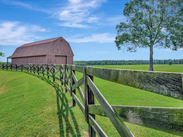 view of yard with an outbuilding, a barn, and fence