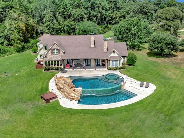 1811 Caspers Cv, Lufkin, TX 75904 - view of swimming pool featuring a patio, a lawn, a wooded view, and a pool with connected hot tub