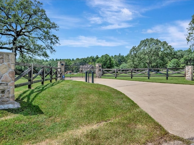 view of home's community with a gate, fence, and a yard