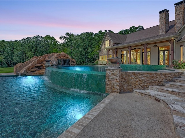 pool featuring a water slide and ceiling fan