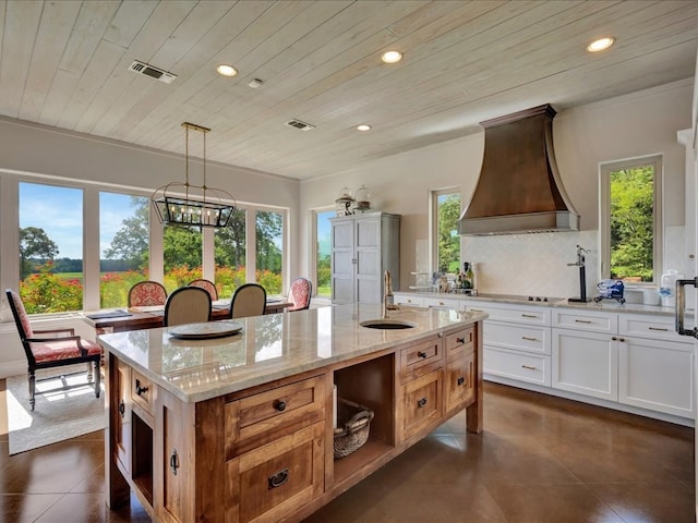 kitchen with visible vents, decorative backsplash, recessed lighting, custom exhaust hood, and a sink