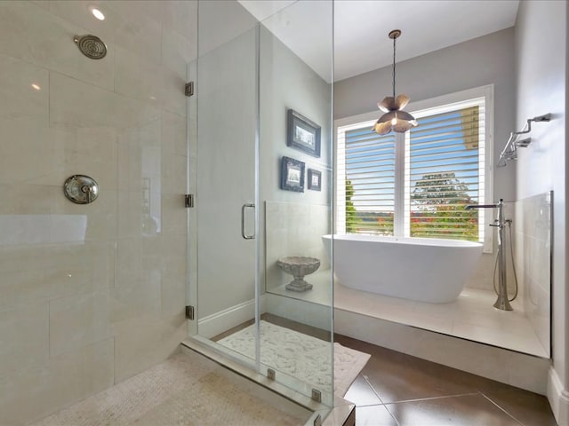 full bathroom featuring tile patterned flooring, a stall shower, and a freestanding tub