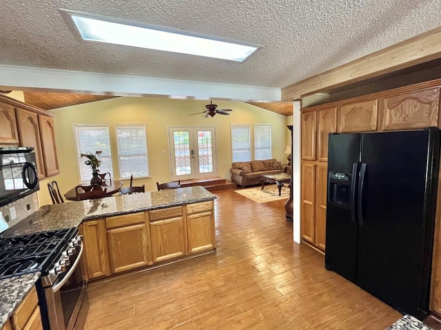 670 Cedar Crest Cir, Hemphill, TX 75948 - kitchen featuring black appliances, a textured ceiling, a peninsula, light wood finished floors, and dark stone countertops