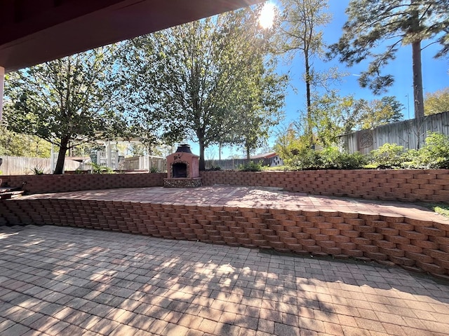670 Cedar Crest Cir, Hemphill, TX 75948 - fenced backyard with an outdoor fireplace and a patio
