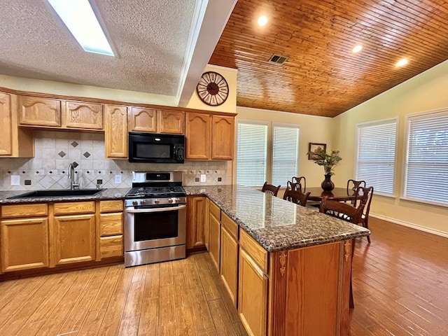 670 Cedar Crest Cir, Hemphill, TX 75948 - kitchen featuring black microwave, gas range, a sink, a peninsula, and lofted ceiling