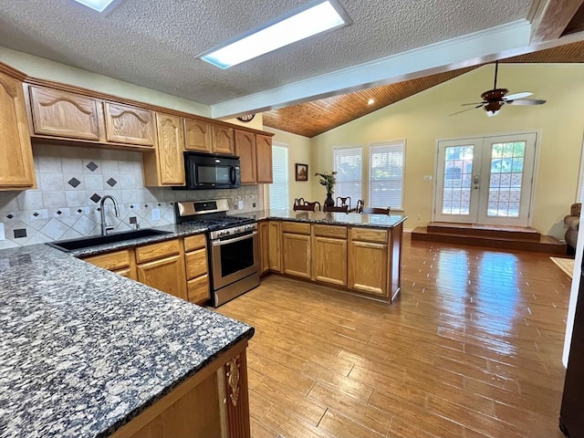 670 Cedar Crest Cir, Hemphill, TX 75948 - kitchen featuring black microwave, gas range, a sink, a peninsula, and lofted ceiling