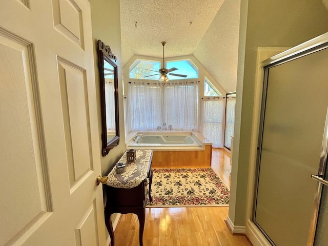 670 Cedar Crest Cir, Hemphill, TX 75948 - bathroom with wood finished floors, ceiling fan, a stall shower, vaulted ceiling, and a bath
