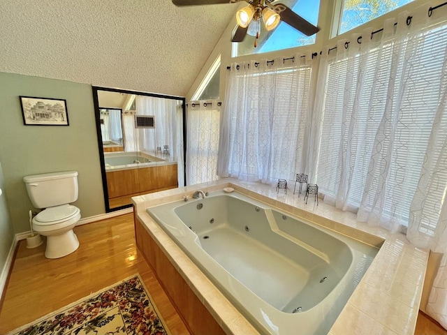 670 Cedar Crest Cir, Hemphill, TX 75948 - full bath with toilet, lofted ceiling, a jetted tub, wood finished floors, and a textured ceiling