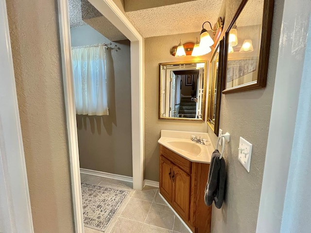 670 Cedar Crest Cir, Hemphill, TX 75948 - bathroom with tile patterned floors, vanity, a textured ceiling, a textured wall, and baseboards