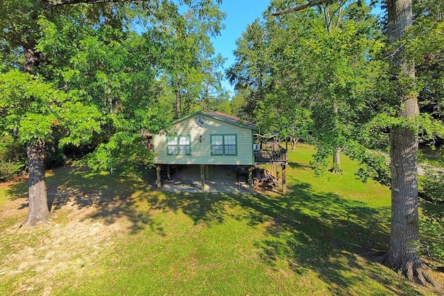 back of property featuring a lawn and a wooden deck