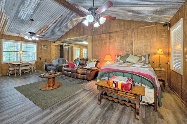 bedroom featuring ceiling fan, wooden walls, lofted ceiling, and hardwood / wood-style flooring