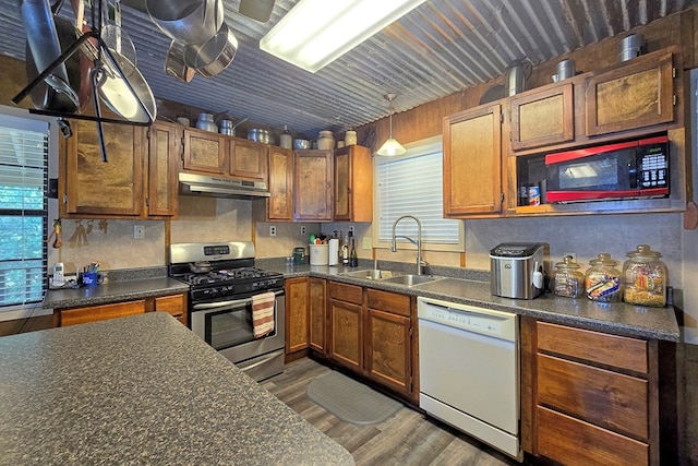 kitchen featuring gas range, dishwasher, sink, dark hardwood / wood-style floors, and decorative light fixtures