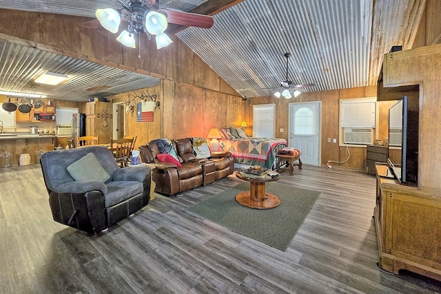 living room featuring wood-type flooring, sink, and wooden walls