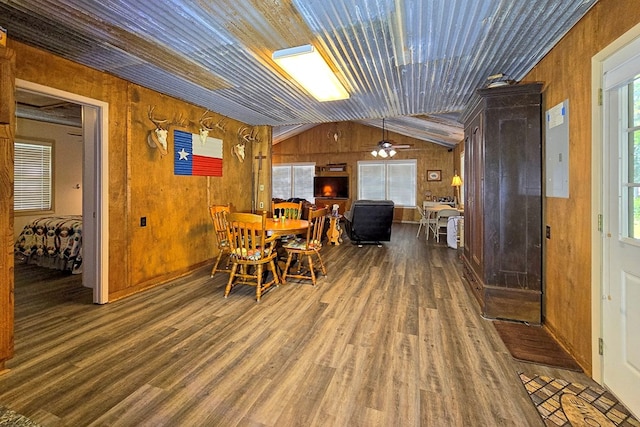 dining room featuring wooden walls, dark hardwood / wood-style floors, ceiling fan, and lofted ceiling