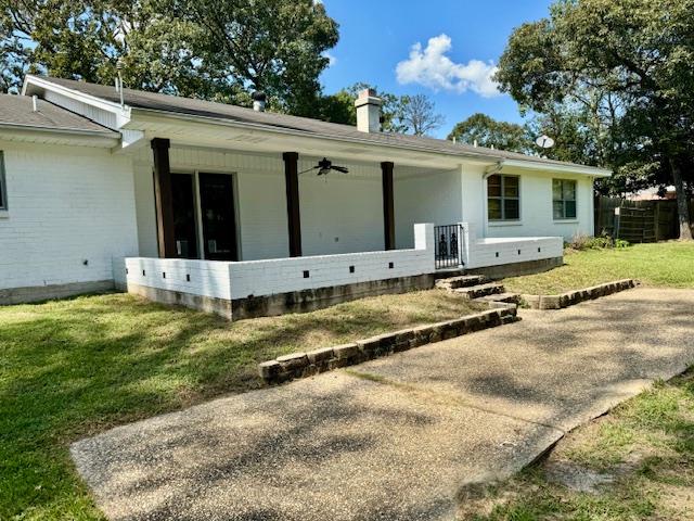 view of property exterior featuring a porch, a yard, and ceiling fan