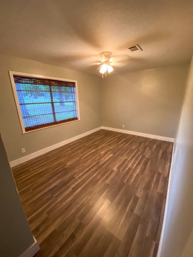 unfurnished room with a textured ceiling, dark hardwood / wood-style floors, and ceiling fan