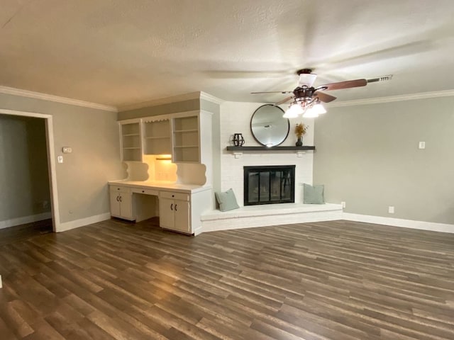 unfurnished living room with crown molding, a brick fireplace, dark hardwood / wood-style floors, ceiling fan, and a textured ceiling