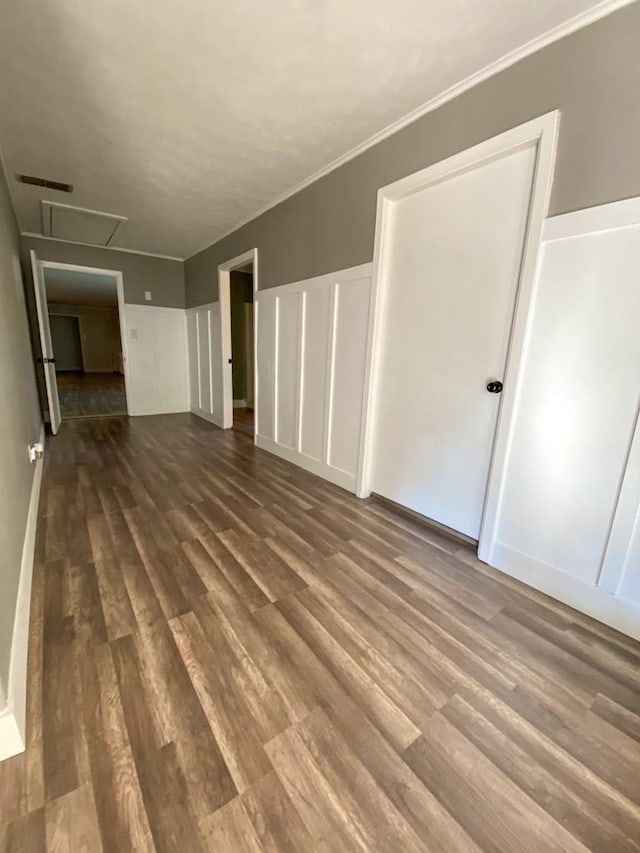 empty room featuring wood-type flooring and crown molding