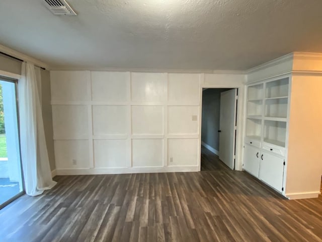 unfurnished room featuring dark wood-type flooring and a textured ceiling