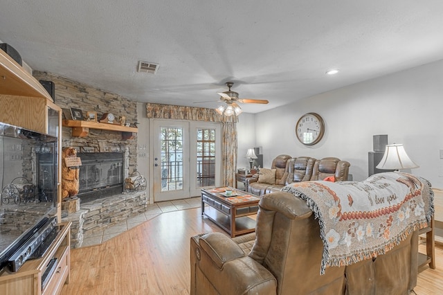 1500 New Haven Rd, Hemphill, TX 75948 - living room featuring a textured ceiling, ceiling fan, light hardwood / wood-style floors, and a fireplace