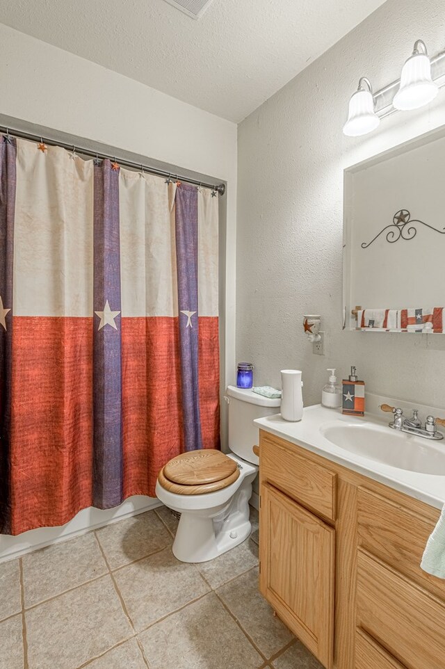 1500 New Haven Rd, Hemphill, TX 75948 - bathroom featuring tile patterned flooring, vanity, a textured ceiling, and toilet