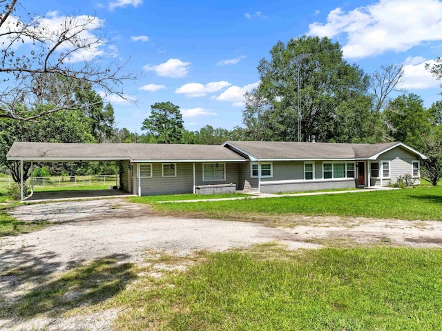 ranch-style home with a carport, covered porch, and a front yard