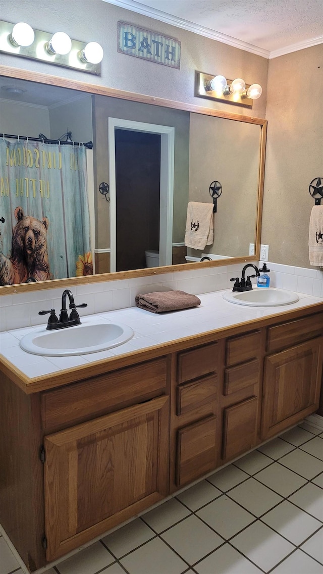 bathroom with tile patterned flooring, a textured ceiling, toilet, vanity, and ornamental molding