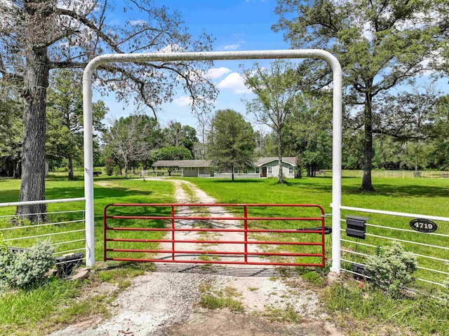 view of gate with a lawn