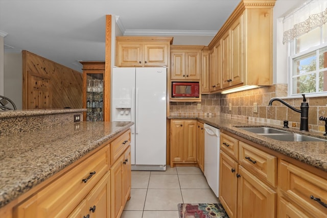 kitchen featuring light stone counters, sink, white appliances, and decorative backsplash