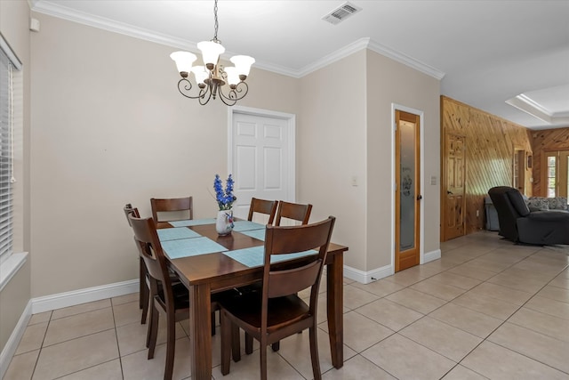 tiled dining room featuring a notable chandelier, wooden walls, and ornamental molding