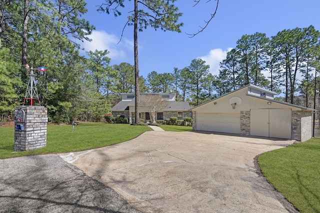 view of front facade with an attached garage, stone siding, concrete driveway, and a front yard