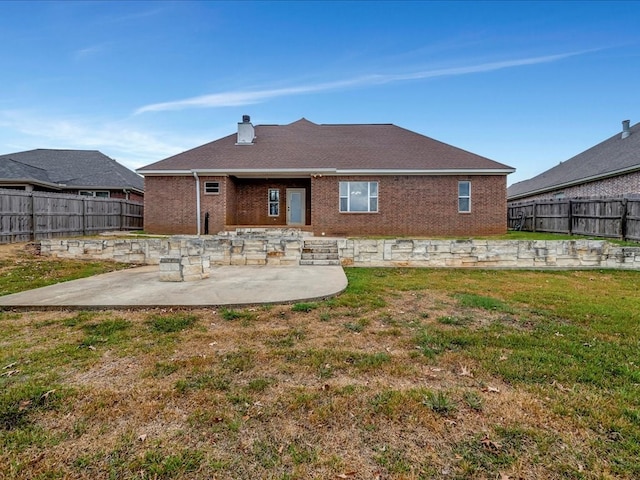 rear view of property with a yard and a patio