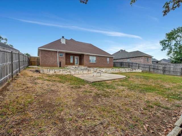 rear view of house with a yard and a patio