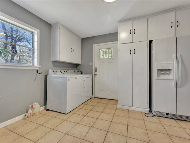 laundry room with cabinets, light tile patterned floors, and separate washer and dryer