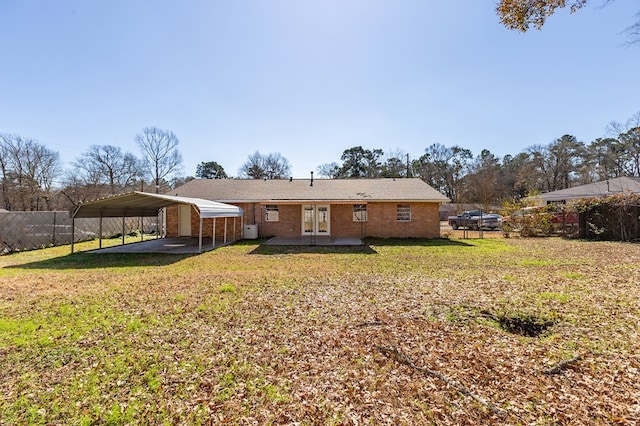 back of house featuring a yard, a carport, and french doors