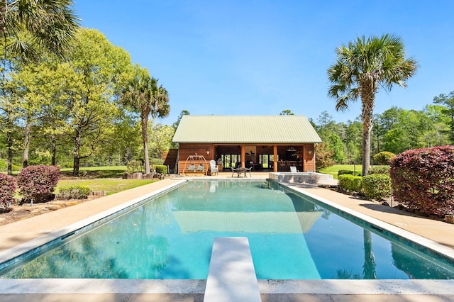 view of pool with a diving board and a patio