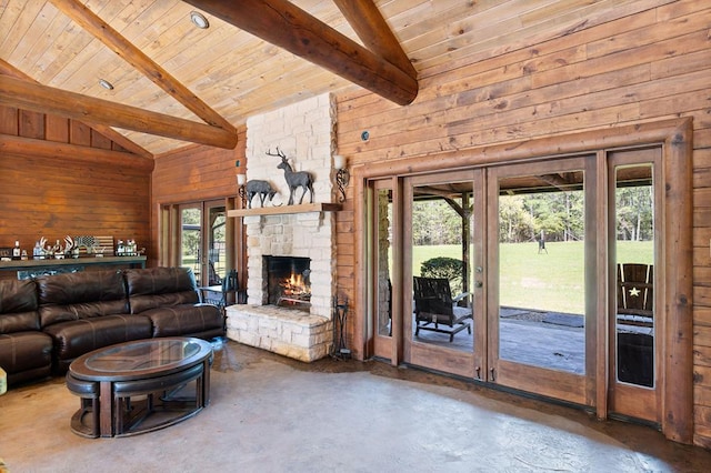 living room with beam ceiling, wood walls, a fireplace, and high vaulted ceiling